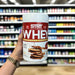 Close-up of (STRT Nutrition Whey Protein 500g) held up inside My Supplement Shop, clearly showing the front label in a Sports Nutrition setting.